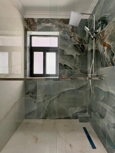 a bathroom with a shower with a glass wall at Villa Klinton in Durrës