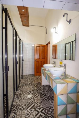 a bathroom with two sinks and a mirror at Hostalgia Casa Zul in Puebla