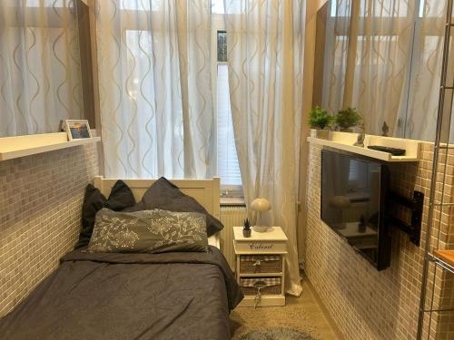 a small bedroom with a bed and a tv at Wohnen im Beauty Salon- im Herzen von Greven in Greven