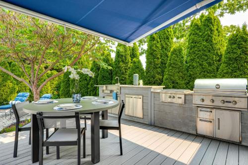 an outdoor kitchen with a table and a grill at Near Solomons Island Boardwalk Home with Hot Tub! in Solomons
