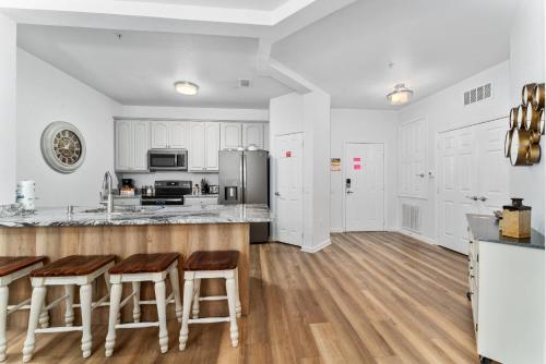 a kitchen with white cabinets and a counter with bar stools at Vista Cay Resort in Orlando