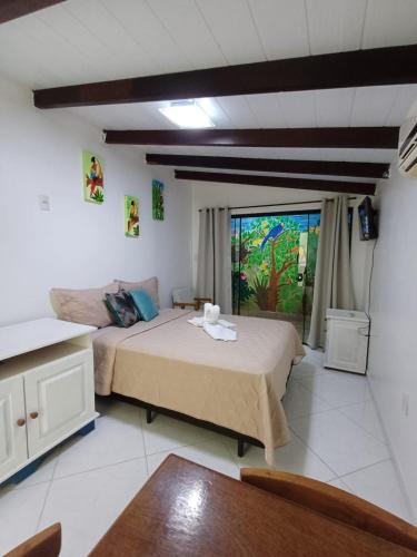 a bedroom with two beds and a large window at Suíte Amazônia in Bombinhas