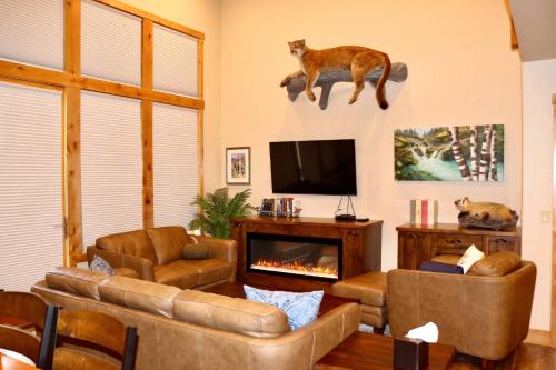 a living room with couches and a tv and a fireplace at Spacious Townhome w 4 King Suites near Clubhouse in Bigfork