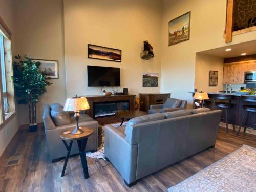 a living room with two couches and a television at Spacious Townhome w 4 King Suites near Clubhouse in Bigfork