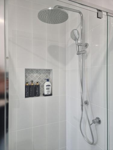 a bathroom with a shower with a glass door at La Luna House in Logan Village