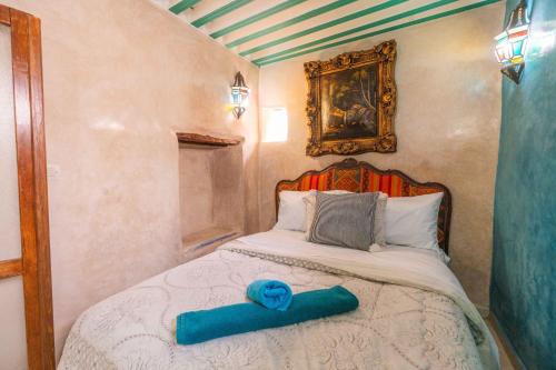 Un dormitorio con una cama con un objeto azul. en Dar Namla, en Essaouira