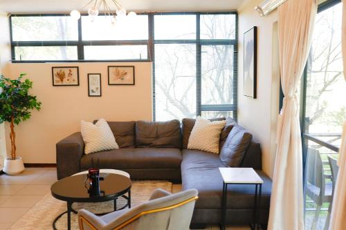 a living room with a couch and a table at Golf Estate Living 1BR Apartment in Jackal Creek in Roodepoort