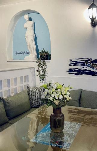 a living room with a vase of flowers on a table at Semiramis Guesthouse in Adamas