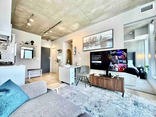 a living room with a couch and a flat screen tv at MicroNest - Modern Overlooking Downtown Parking in Calgary