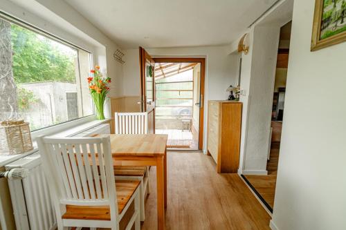 a dining room with a table and chairs and a window at Träumen unter Bäumen - Omas lütte Obstbutze am See in Lübstorf