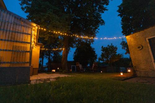 a string of lights hanging over a yard at night at Träumen unter Bäumen - Omas lütte Obstbutze am See in Lübstorf