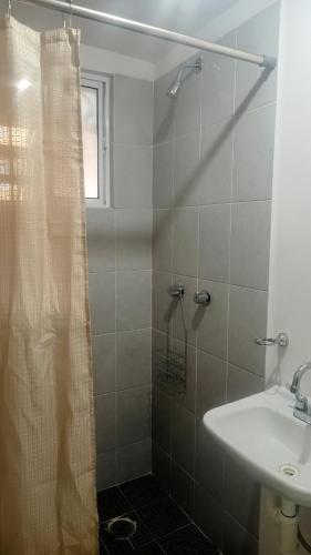 Un baño con cortina de ducha y lavabo. en Departamento en Real Granada, en Santa Cruz Tecamac