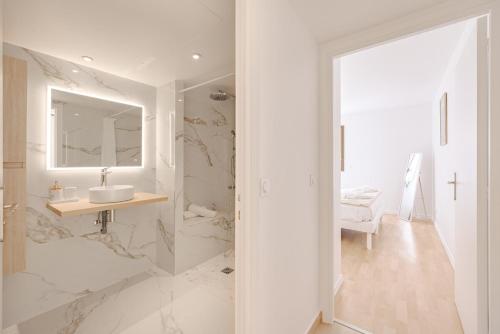 une salle de bain blanche avec un lavabo et un miroir dans l'établissement Cannes 2 bedrooms apartment - 141A, à Cannes