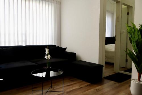 a living room with a black couch and a table at San Suite in Netanya