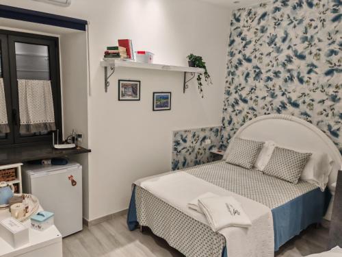 1 dormitorio con 1 cama con papel pintado azul y blanco en DOMUS ULIVI LUXURY ROOMS Moresca, en Catania