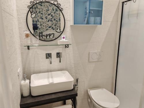 Un baño con lavabo, inodoro y espejo. en DOMUS ULIVI LUXURY ROOMS Moresca, en Catania