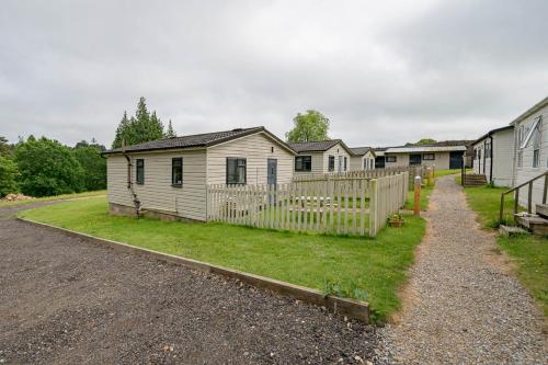 a row of houses with a fence and a yard at Oak Cabin Overlooking Bedgebury Forest in Goudhurst