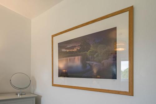 a picture hanging on a wall in a room at Oak Cabin Overlooking Bedgebury Forest in Goudhurst