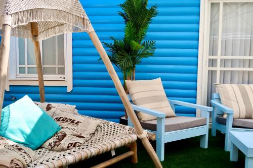 a blue room with a swinging chair and a blue wall at San Suite in Netanya