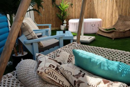 a patio with a couch and a chair and pillows at San Suite in Netanya