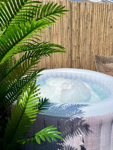 a bath tub filled with water next to a plant at San Suite in Netanya