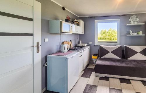 a small kitchen with white cabinets and a window at Awesome Apartment In Zastan With Wifi in Zastań