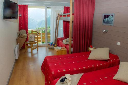 a bedroom with red curtains and a bed with a teddy bear on it at Village Vacances Le Tarbesou in Ax-les-Thermes