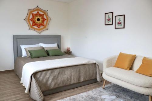 a bedroom with a bed and a couch and a chair at Suites de Braga in Braga