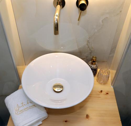 a bathroom with a white sink and a faucet at Yataki Cozy House in Plomarion