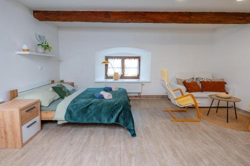 a bedroom with a bed and a chair in it at Klidné místo in Třeboň