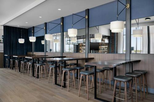 a dining room with black tables and stools at AC Hotel by Marriott Bentonville in Bentonville