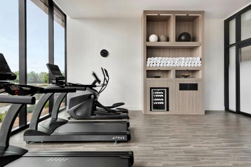 a fitness room with a treadmill and a gym at AC Hotel by Marriott Bentonville in Bentonville