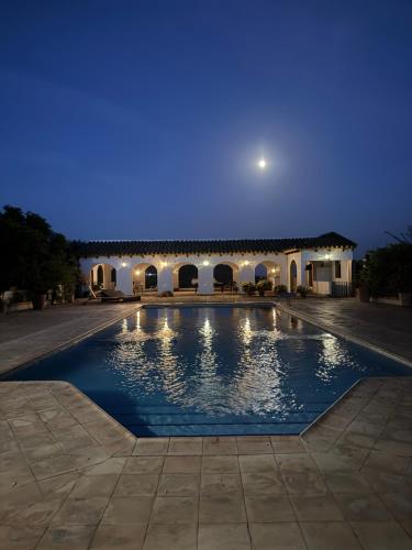 ein Schwimmbad vor einem Gebäude bei Nacht in der Unterkunft Finca Jaralta de Carmen in La Puebla de los Infantes