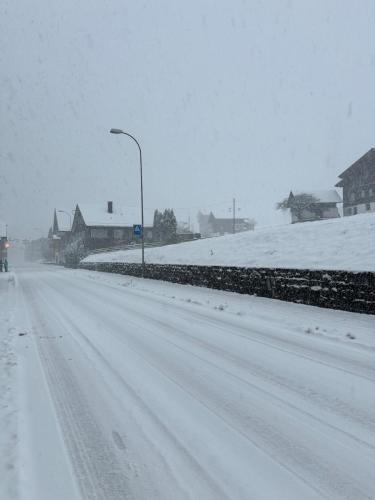 a snow covered road with a street light and houses at Bijou N 2 Lungern in Lungern
