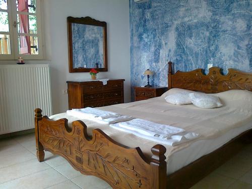 アサニオンにあるHarmony and Horizon villasのベッドルーム1室(大型木製ベッド1台、タオル付)