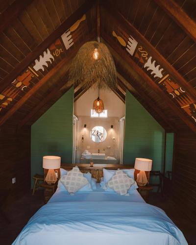 a bedroom with a large bed with blue sheets at qema Mancora in Máncora