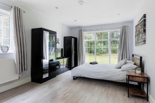a bedroom with a bed and a large window at Jaw Dropping House with Hot Tub & Heated Private Indoor Pool in Peover Superior