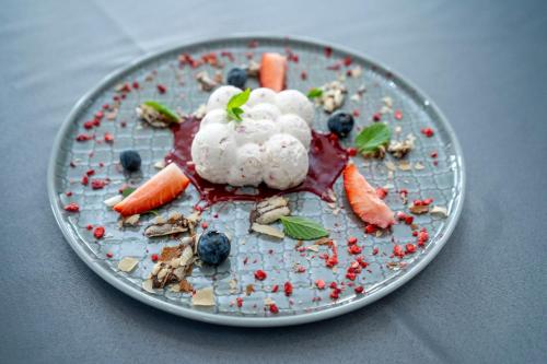 a plate of food with ice cream and berries on it at Hotel Atena Wedding, Business & Spa in Ciechanów