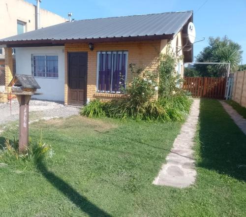 a house with a grass yard with a house at Casa Los colibrí in Frente Mar