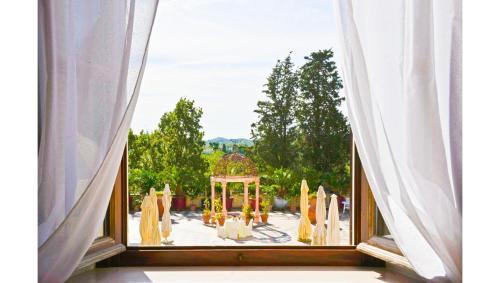 ein offenes Fenster mit Blick auf einen Pavillon in der Unterkunft Residenza il Poggione in Fauglia