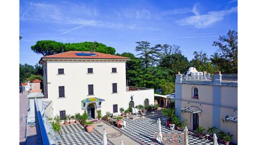 une vue aérienne sur un bâtiment blanc avec un toit dans l'établissement Residenza il Poggione, à Fauglia