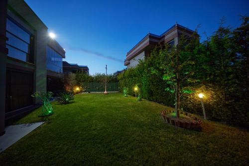 a garden at night with lights on the grass at Andalus Villas NO ALCOHOL ALLOWED with Heated Pool in Sapanca