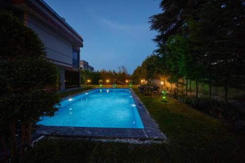 a swimming pool in the yard of a house at night at Andalus Villas NO ALCOHOL ALLOWED with Heated Pool in Sapanca