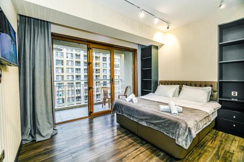 Un dormitorio con una cama grande y una ventana grande en Park Azure One Bedroom Luxury Apartment, en Baku