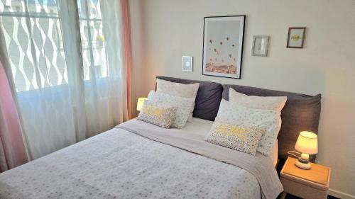 une chambre avec un lit avec des oreillers et une fenêtre dans l'établissement Le chic moderne Disney Paris, à Chessy