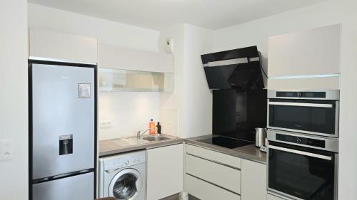 Il comprend une cuisine équipée d'un réfrigérateur et d'un lave-linge/sèche-linge. dans l'établissement Le chic moderne Disney Paris, à Chessy
