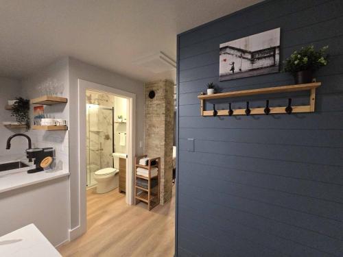 a blue wall in a bathroom with a toilet at Stylish Modern Studio in Vibrant Walker's Point in Milwaukee