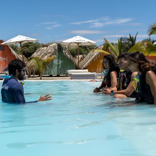 a group of people sitting in a swimming pool at qema Mancora in Máncora