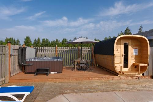 a wooden deck with a sauna and an umbrella at Cavendish Lodge & Cottages in Cavendish
