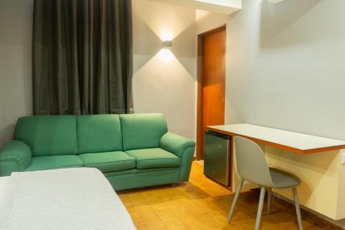 a living room with a green couch and a table at Hotel El Arroyo in Caracas